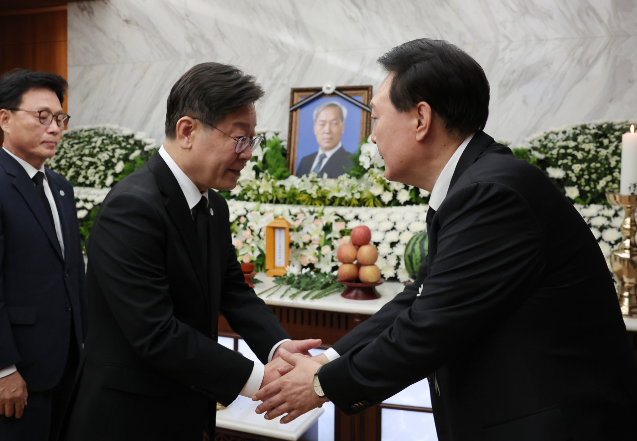 President Yoon Suk Yeol (right) accepts condolences from Democratic Party of Korea leader Lee Jae-myung at the funeral hall of Sinchon Severance Hospital in Seodaemun-gu, Seoul, Tuesday. The ceremony was prepared for Yoon's father, Yoon Ki-jung, an emeritus professor at Yonsei University. (Yonhap)