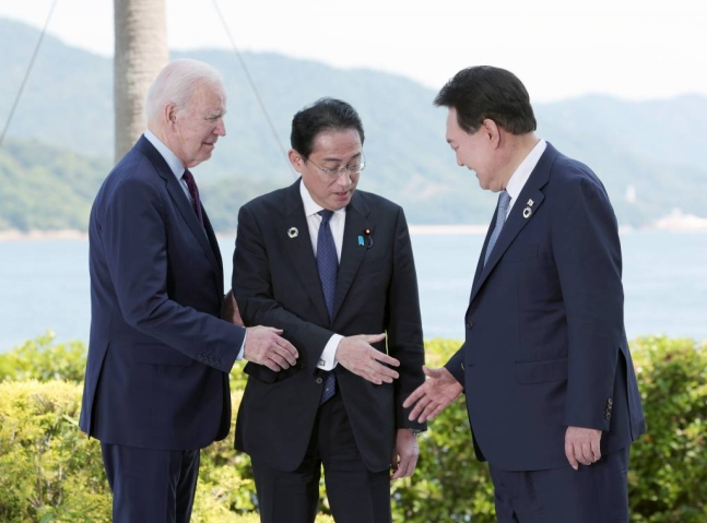 South Korean President Yoon Suk Yeol (right) shakes hands with US President Joe Biden (left) and Japanese Prime Minister Fumio Kishida at their three-way talks in Hiroshima, Japan, in May. (Joint Press Corps)