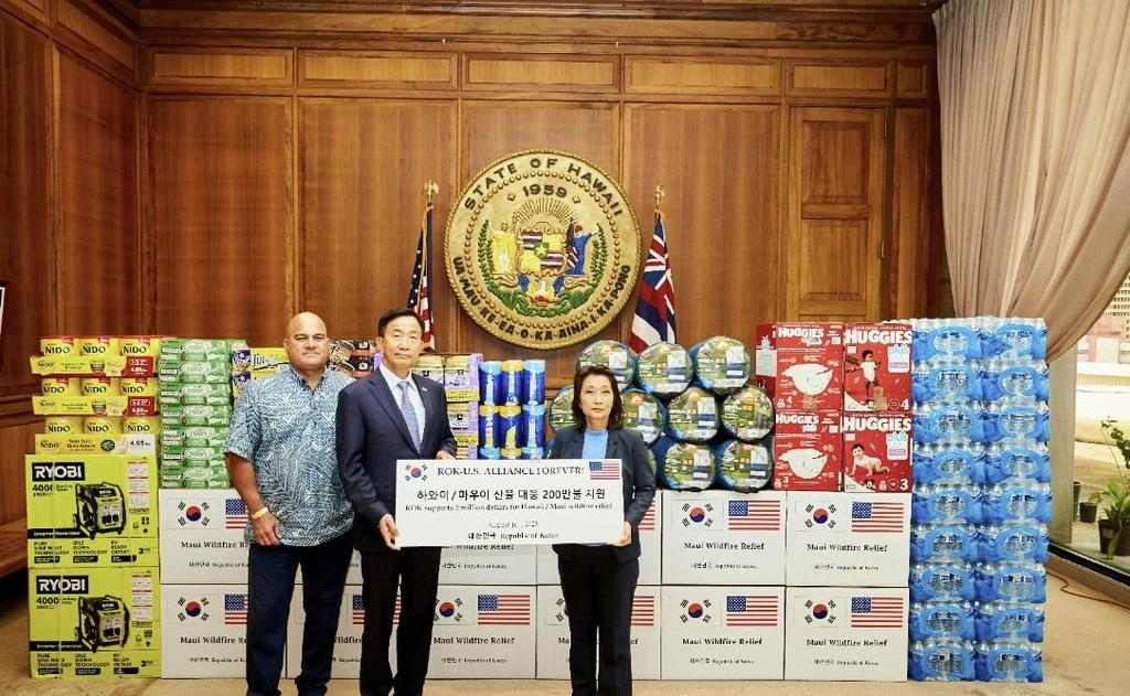 South Korean consul general in Honolulu Lee Seo-young (centre) poses for a photo with Hawaii's Lieutenant Governor Sylvia Luke (right) at a ceremony on Wednesday, to deliver relief supplies to Hawaii to help the US state cope with the recent outbreak of wildfires. (Seoul's foreign ministry)