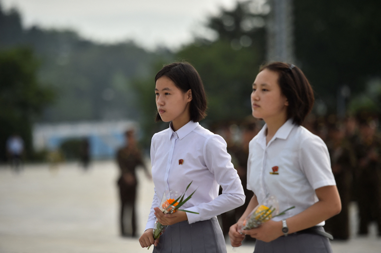 People pay their respects before the statues of late North Korean leaders Kim Il Sung and Kim Jong Il at Mansu Hill as North Korea marks its 78th National Liberation Day, commemorating the end of Japanese colonial rule in 1945, in Pyongyang on Tuesday. (AFP)