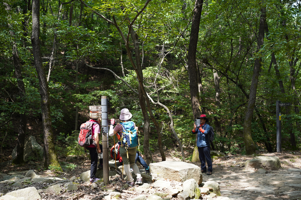 Hikers take a photo along Gwanaksan's walking trail on Tuesday. (Lee Si-jin/The Korea Herald)