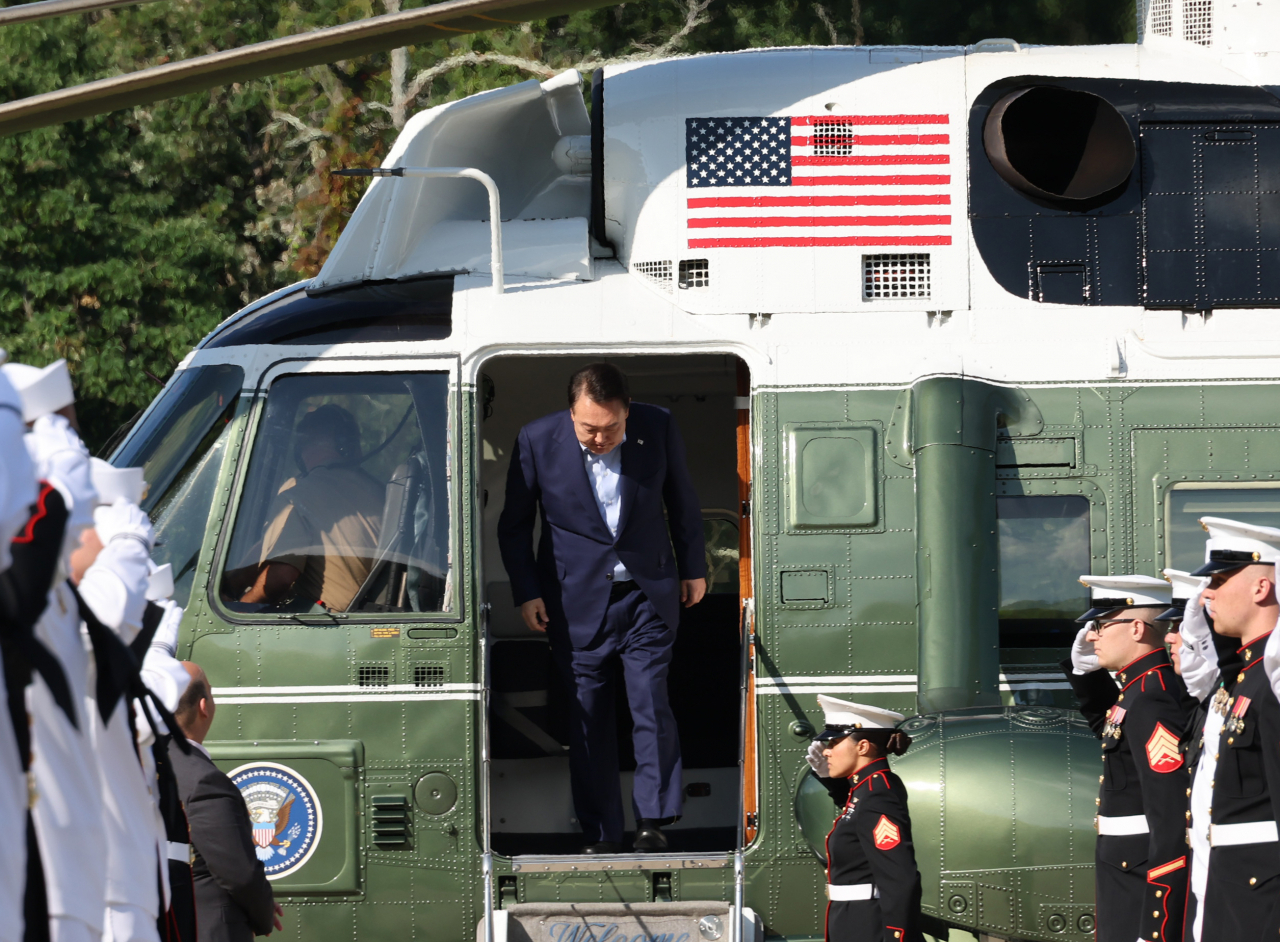 President Yoon Suk Yeol disembarks a helicopter as he arrived at the Camp David presidential retreat in Md. on Friday. (Yonhap)