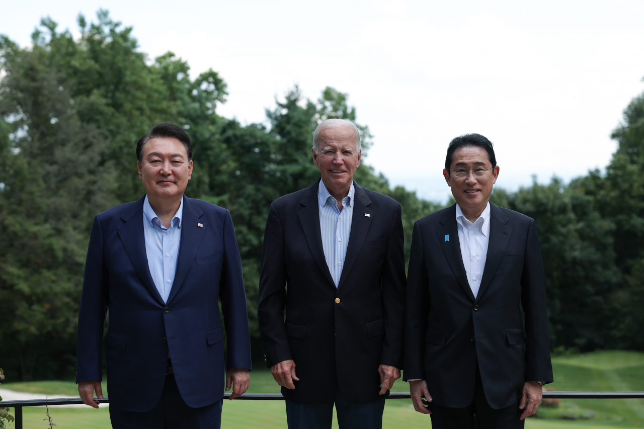 South Korean President Yoon Suk Yeol (left) poses for a photo with US President Joe Biden (center) and Japanese Prime Minister Fumio Kishida as they attend a luncheon following a trilateral summit meeting at the Camp David presidential retreat in Maryland last Friday. (Yonhap)