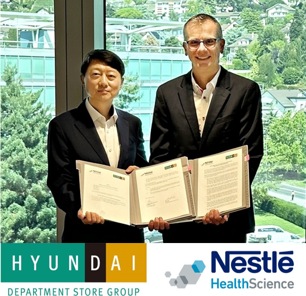 Hyundai Department Store Group President Jang Ho-jin (left) and CEO of Nestle Health Science Greg Behar pose for a photo during a memorandum of understanding signing ceremony at Nestle headquarters in Switzerland, Monday. (Hyundai Department Store Group)