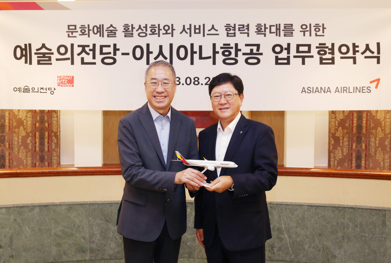 Asiana Airlines Vice President Won Yoo-suk (right) and Seoul Arts Center President Chang Hyoung-joon pose for a photo after signing a memorandum of understanding at SAC's Opera Theater, Tuesday. (Asiana Airlines)