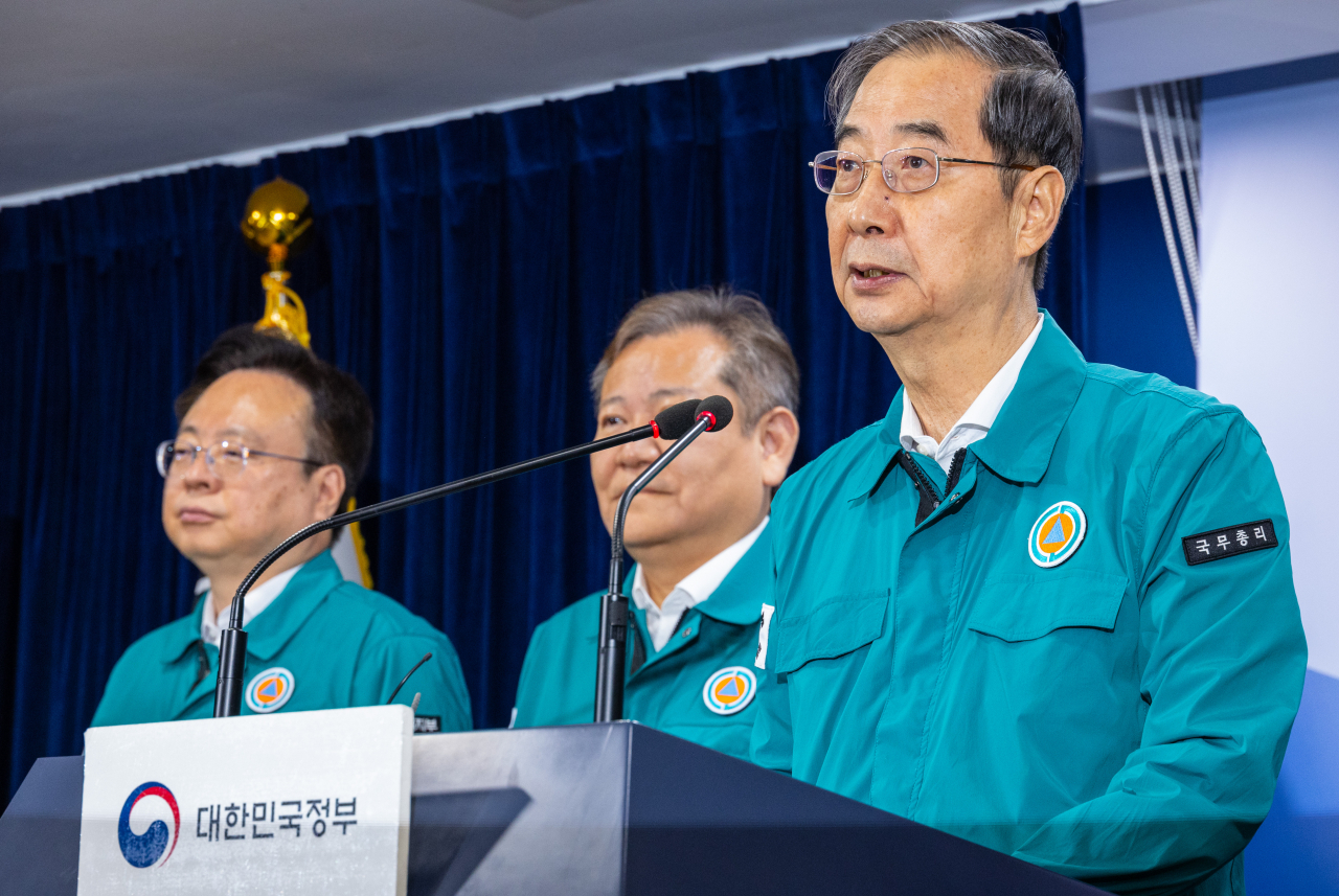 Prime Minister Han Duck-soo (right) makes a public speech at the government complex in Seoul on Wednesday. (Yonhap)