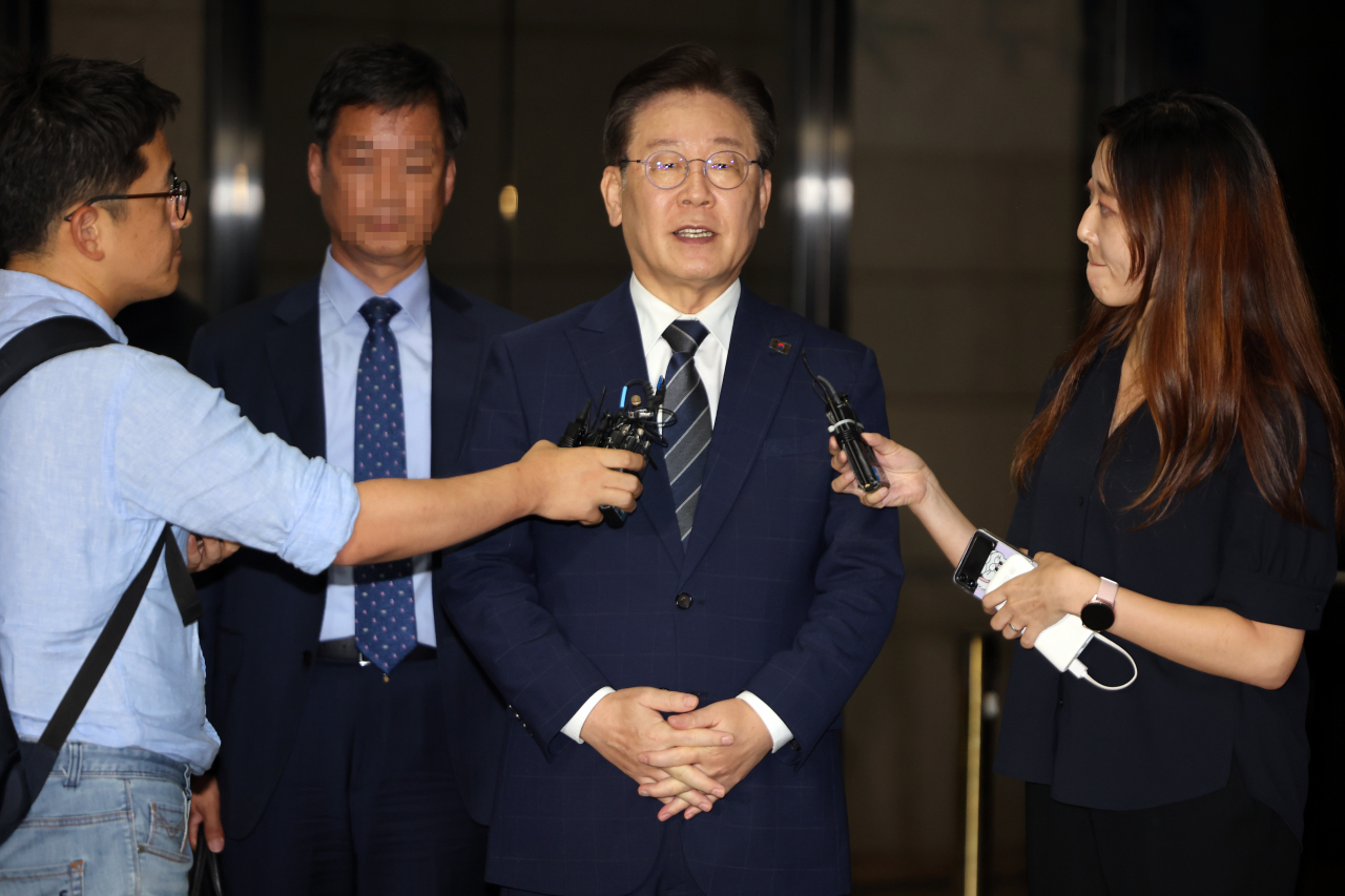 In this file photo, Democratic Party leader Lee Jae-myung (center) speaks to reporters after undergoing questioning at the Seoul Central District Prosecutors Office in southern Seoul on Aug. 18. (Yonhap)