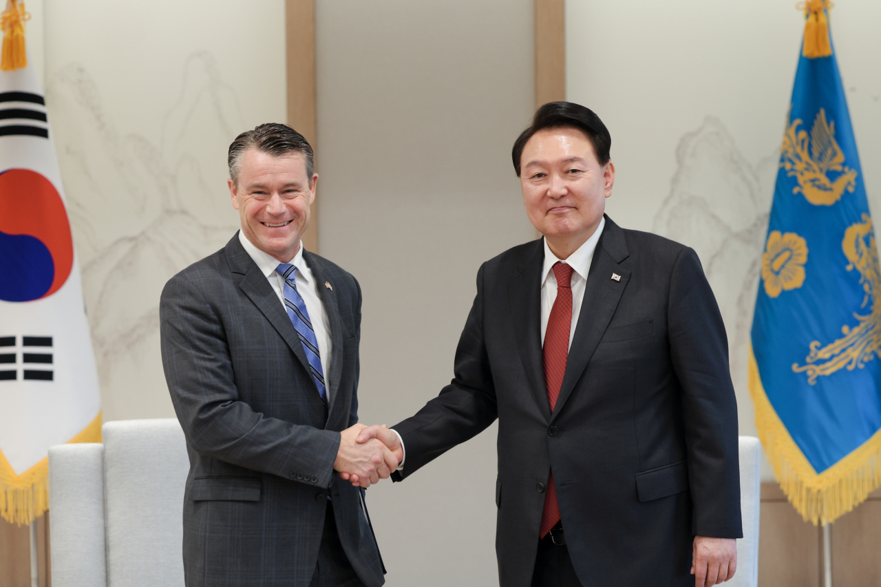 President Yoon Suk Yeol (right) shakes hands with Sen. Todd Young (R-IN) during their meeting at the presidential office in Seoul on Tuesday. (Yonhap)