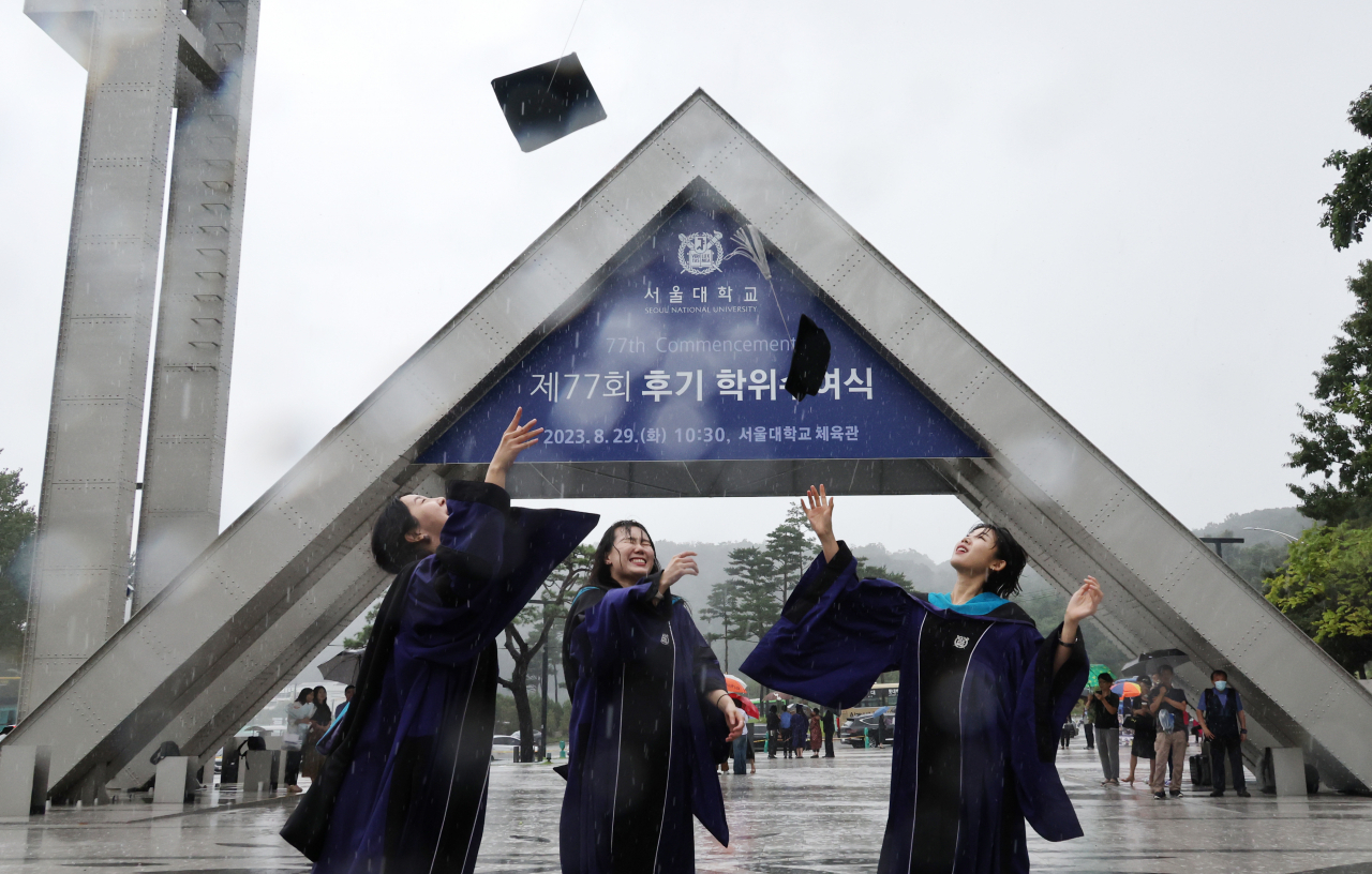 Students throw their graduation caps into the air at Seoul National University. (Yonhap)