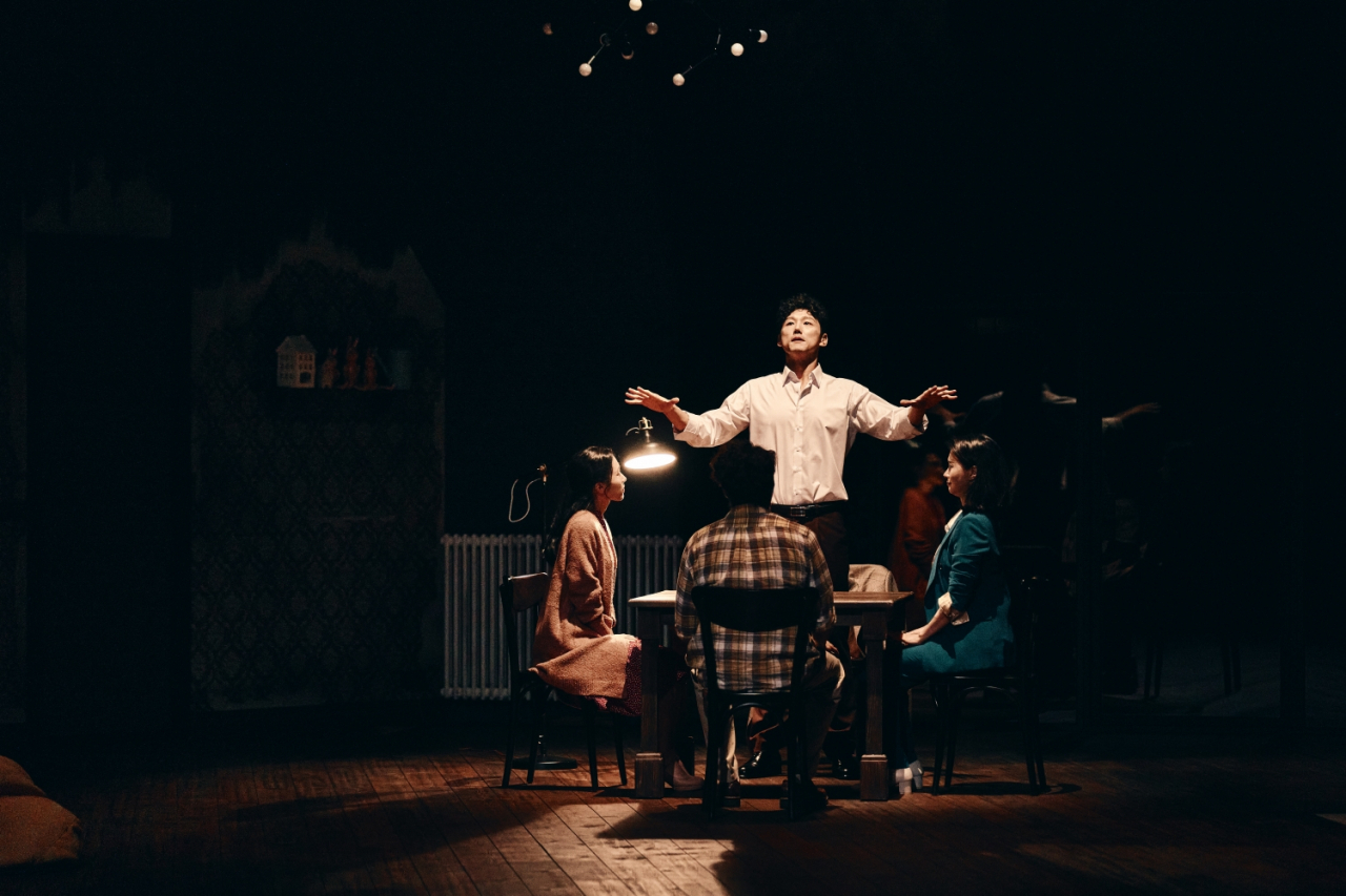 Ben, played by Yang Seung-ri (standing), conducts a ritual to communicate with a spirit in a scene from “2:22 A Ghost Story.” (Seensee Company)