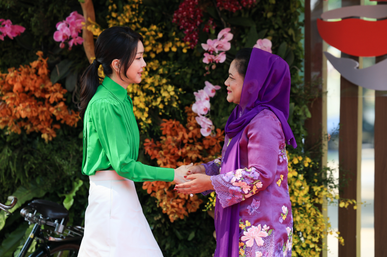First lady Kim Keon Hee (left) is greeted by Indonesian first lady Iriana Widodo at Taman Mini Indonesia Indah on Wednesday. (Joint Press Corps.)