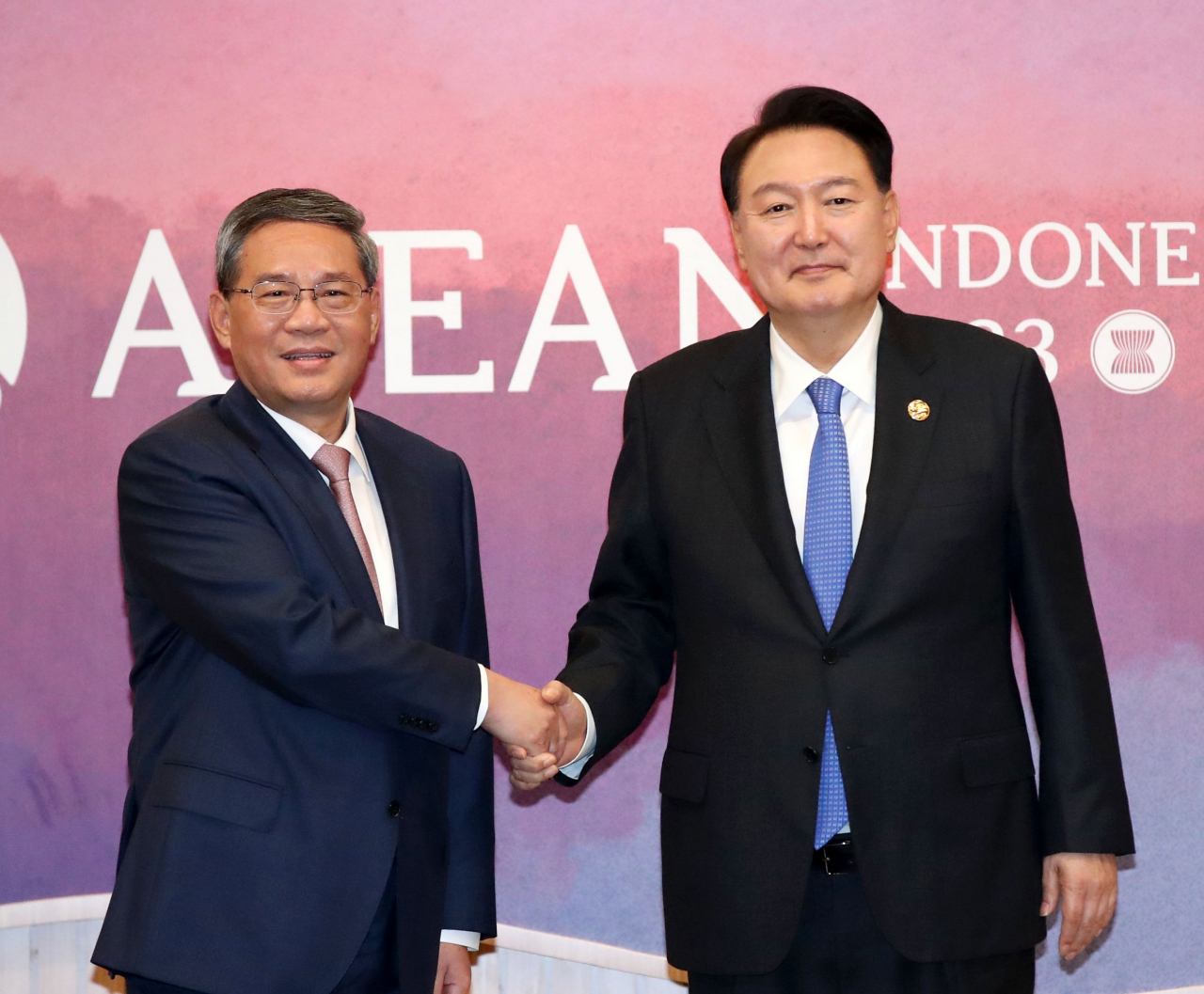 President Yoon Suk Yeol (right) shakes hands with Chinese Premier Li Qiang at the Korea-China meeting held at the Jakarta Convention Center in Indonesia on Thursday. (Yonhap)