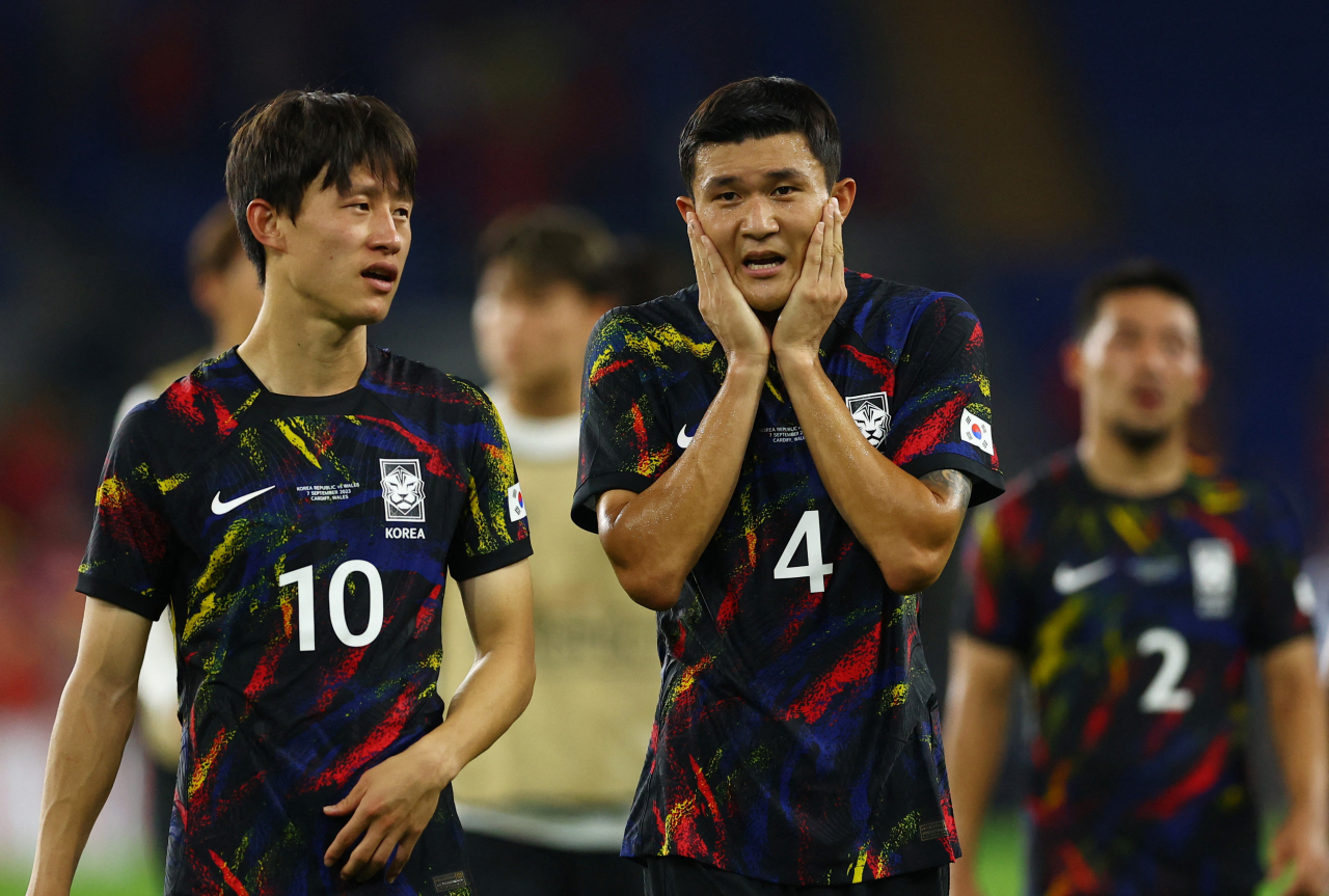 Kim Min-jae (right) and Lee Jae-sung of South Korea react to a goalless draw against Wales in the teams' friendly football match at Cardiff City Stadium in Cardiff on Thursday. (Yonhap)