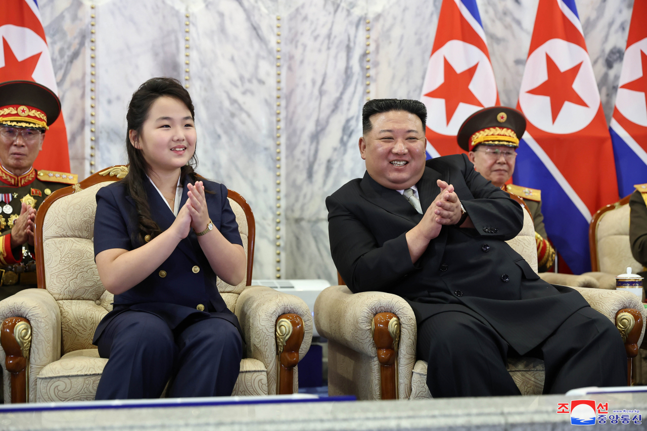 North's leader Kim Jong-un (R) and his daughter, believed to be named Ju-ae, attending a paramilitary parade in Pyongyang to mark the 75th anniversary of the regime's founding day on Saturday. (KCNA)