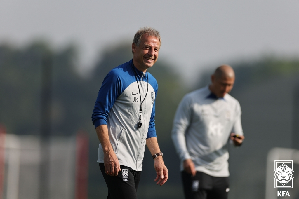 Jurgen Klinsmann (left), head coach of the South Korean men's national football team, smiles during a training session at Brentford FC Training Ground in Osterley, England, on Sunday. (Yonhap)