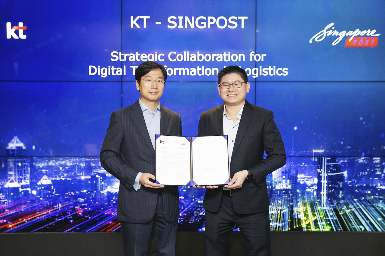 Choi Kang-rim, head of AI mobility business at KT (left) and Eric Yeo, head of business technology solutions and property at Singapore Post, pose for a photo during a memorandum of understanding signing ceremony at KT office in Seoul, Thursday. (KT Corp.)