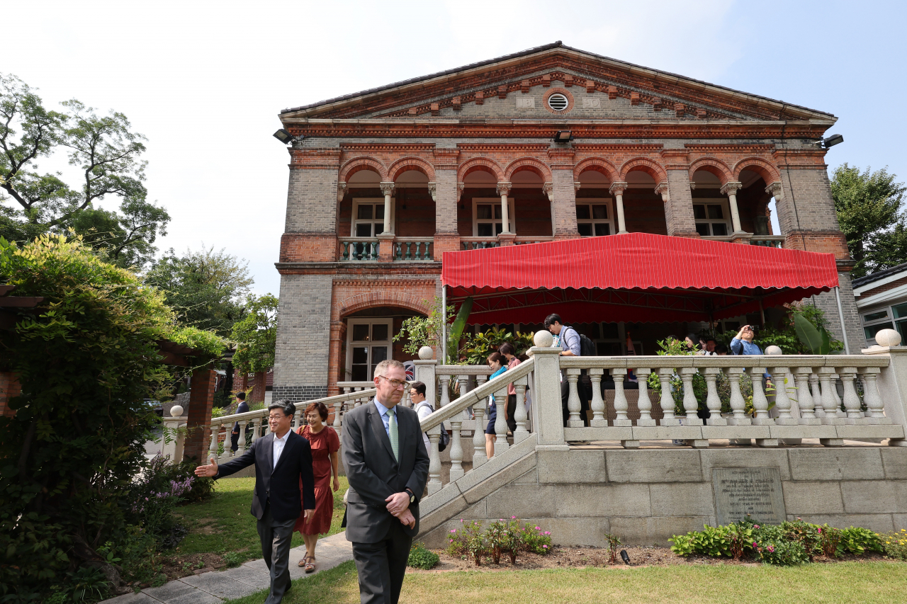 Colin Crooks, the British ambassador to South Korea, leads visitors to the garden outside his residence in the historical neighborhood of Jeong-dong, Seoul, on Monday. (Yonhap)
