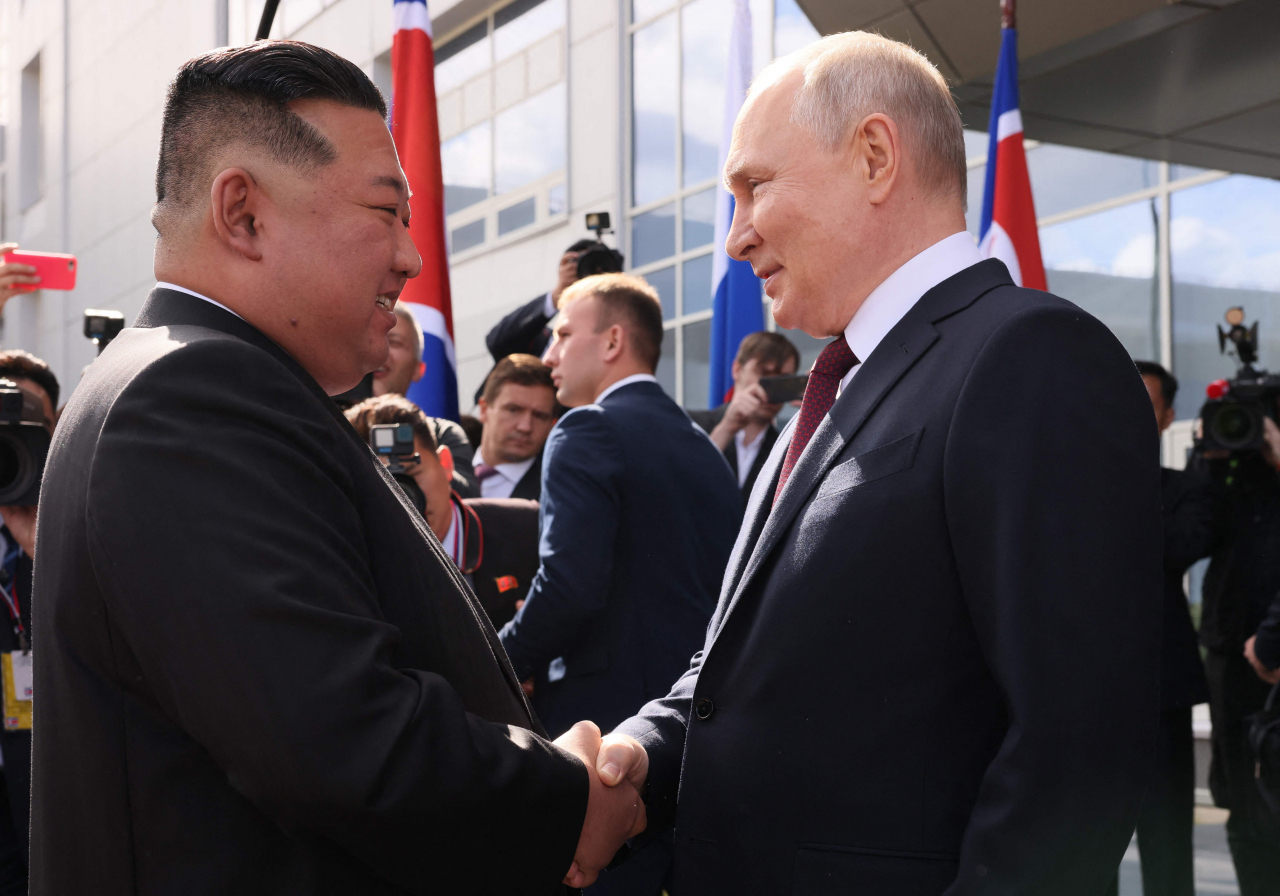 In this pool photo distributed by Sputnik agency, Russia's President Vladimir Putin (right) shakes hands with North Korea's leader Kim Jong-un during their meeting at the Vostochny Cosmodrome in Amur region on Wednesday. (AFP)