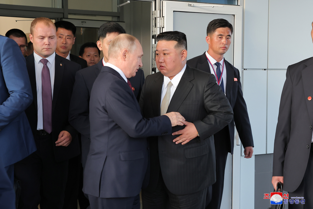 North Korean leader Kim Jong-un (right) talks with Russian President Vladimir Putin after attending a dinner, hosted by Putin, at the Vostochny Cosmodrome space launch center in the Russian Far East on Wednesday in this photo released by the North's official Korean Central News Agency the next day. Kim invited Putin to visit his country. (Yonhap)