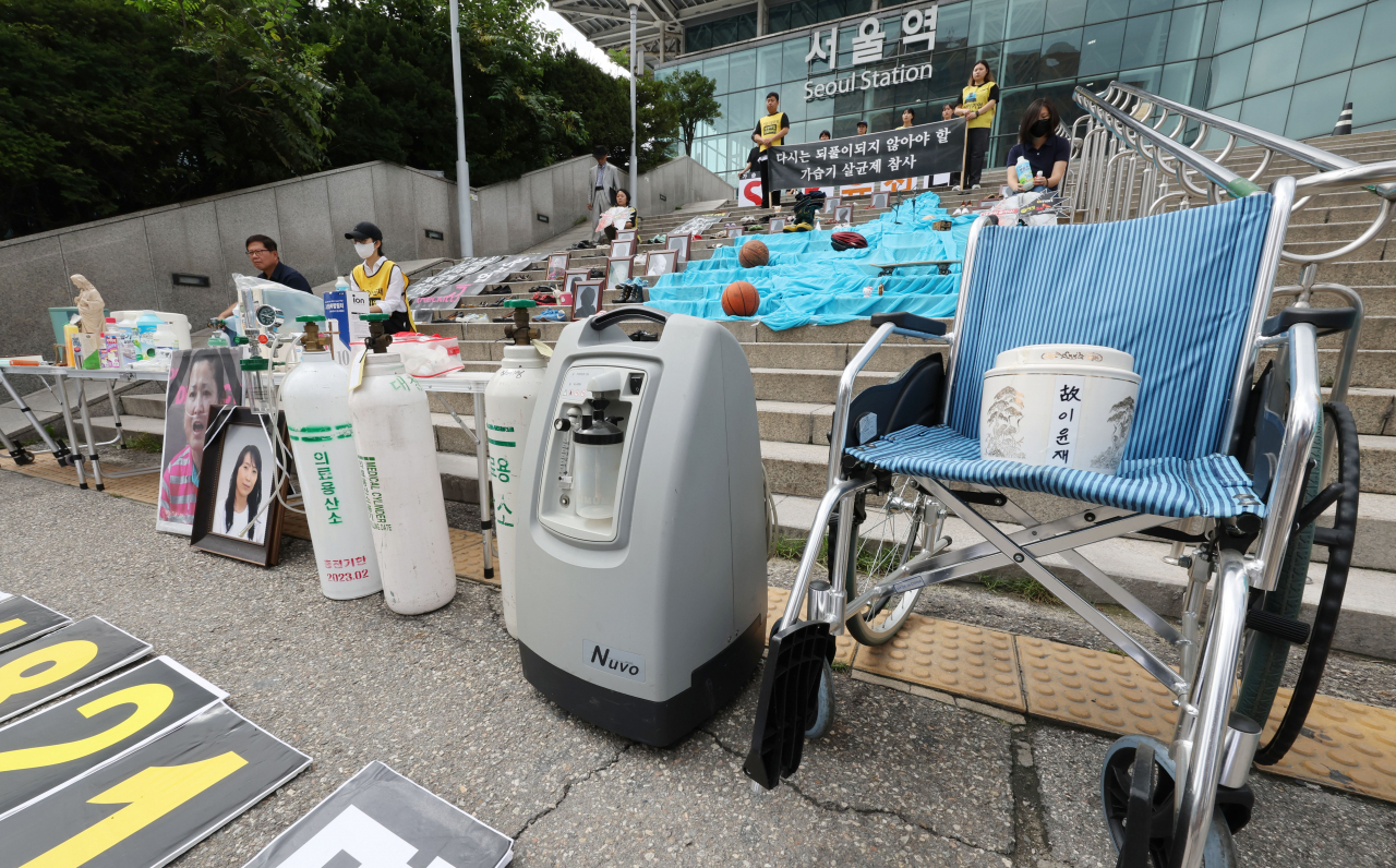 A press conference for the 12th anniversary of the toxic humidifier sterilizer case is held in front of Seoul Station on Aug. 31. Belongings of the deceased victims from the case are placed at the steps in front of the station. (Yonhap)