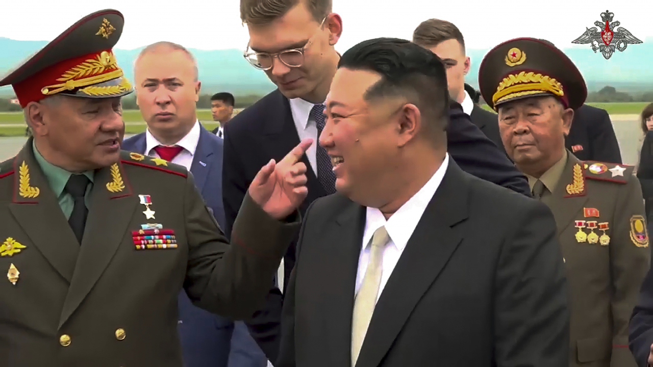 In this photo taken from video released by Russian Defense Ministry Press Service, North Korea's leader Kim Jong Un, right, smiles to Russian Defense Minister Sergei Shoigu, left, as he inspects Russian warplanes at the Vladivostok International airport in Vladivostok, Russian Far East on Saturday. (Photo - AP)