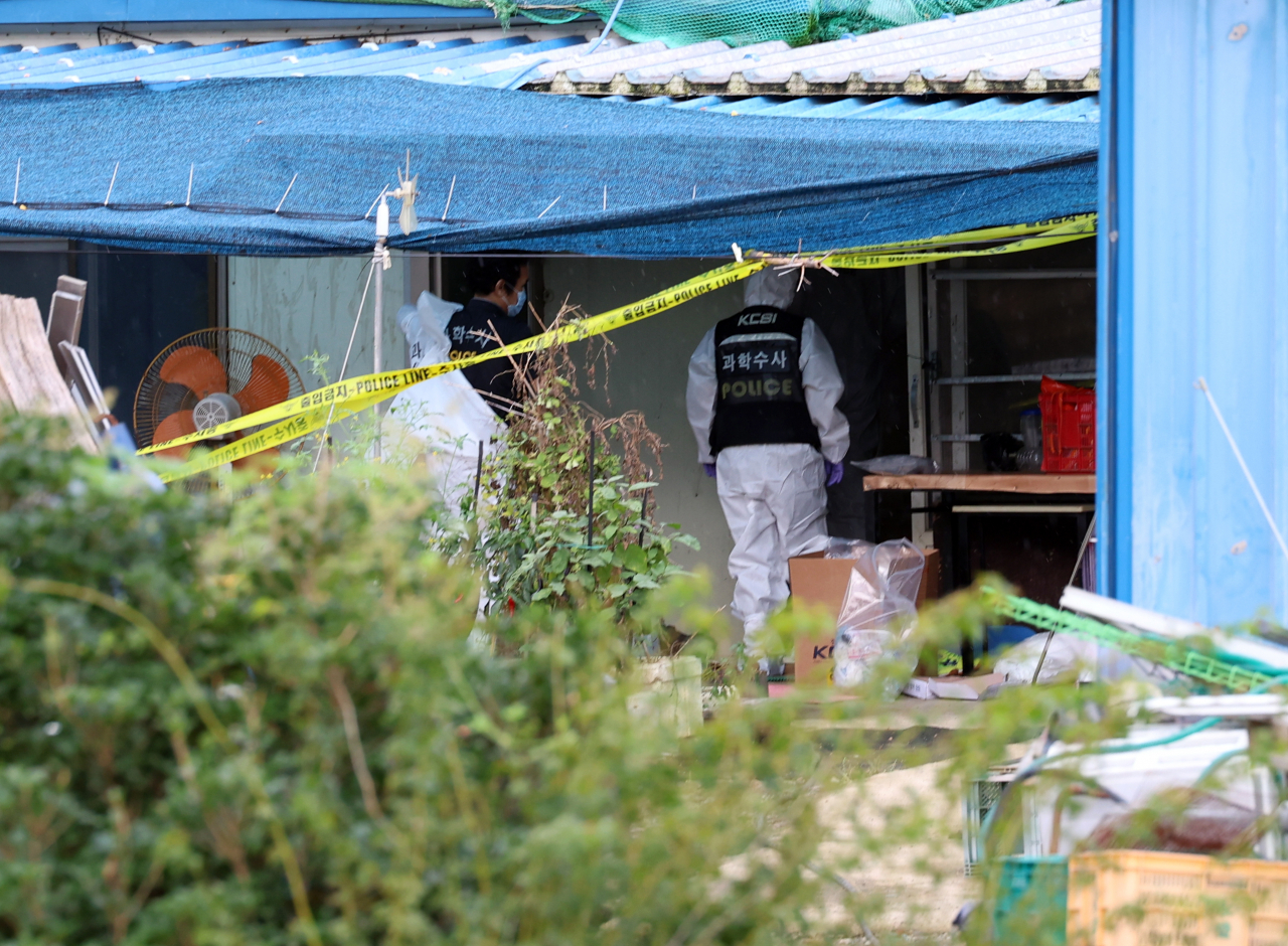 Police conduct a forensic examination in a family home in Yeongam, South Jeolla Province, on Saturday, where a family of five was found dead the day before. (Yonhap)