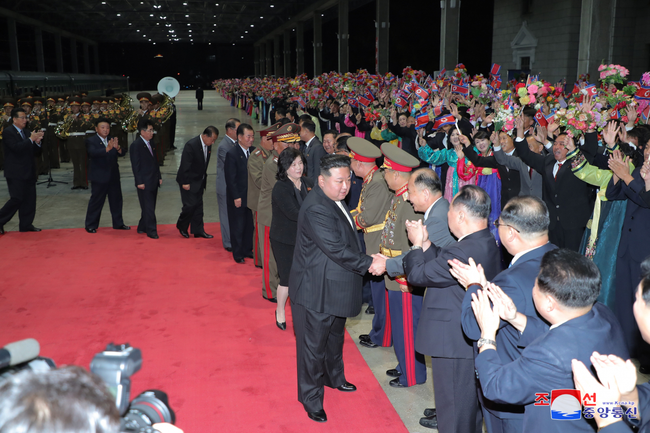This photo on Wednesday shows the North's leader Kim Jong-un (center) welcomed by a cheering crowd and top officials at Pyongyang Railway Station after a special train carrying him arrived in Pyongyang the previous day after a trip to Russia. (KCNA)