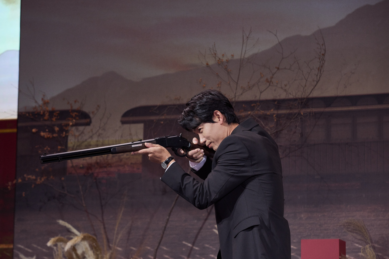 Kim Nam-gil poses with the Winchester rifle during a press conference on Tuesday. (Netflix)
