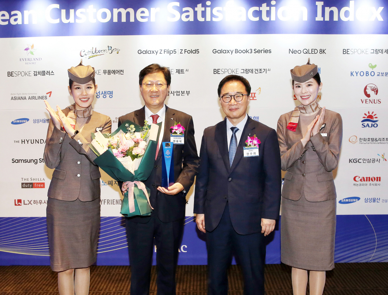 Asiana Airline CEO Won Yoo-seok (center left) and Korea Management Association Consultants CEO Han Soo-hee (center right) pose for a photo during an award ceremony held in Seoul, Thursday. (Asiana Airline)