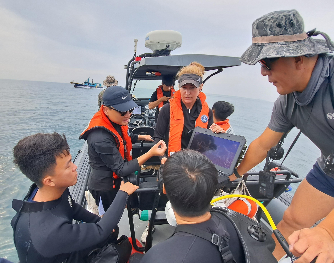 South Korean and US divers, aboard a high-speed boat, perform on-site analysis of the underwater survey results and engage in discussions regarding their findings. (Photo courtesy of the Ministry of National Defense Agency for Killed in Action Recovery Identification)
