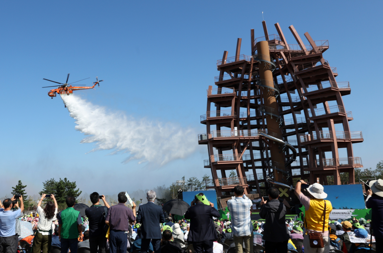 A helicopter belonging to the Korea Forest Service puts on a fire extinguishing demonstration during the opening ceremony of the Gangwon Forestry Exhibition 2023 on Friday in Goseong, Gangwon Province. (Yonhap)