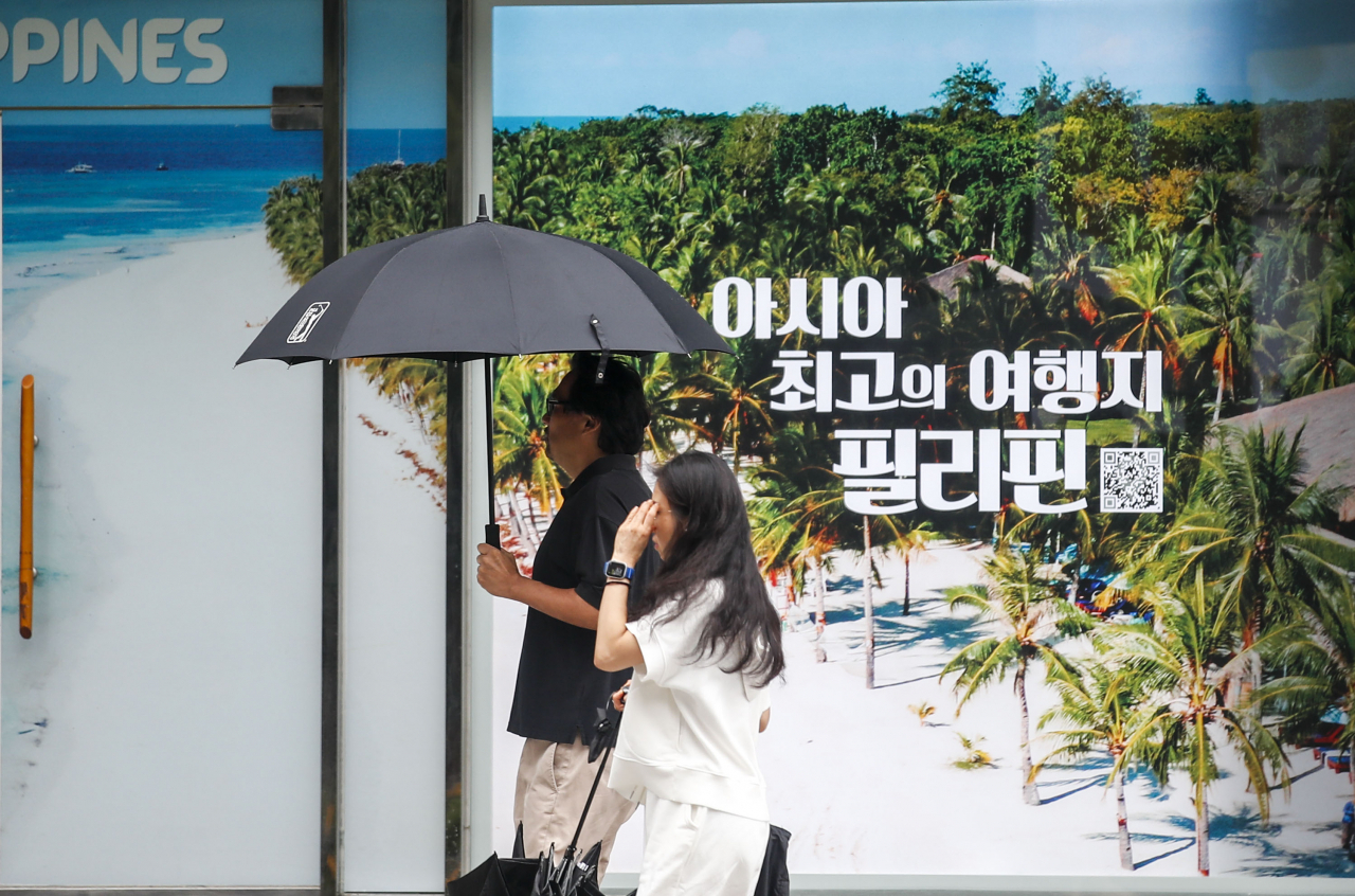 People walk past a travel agency's office in Seoul, Aug. 29, 2023. (Newsis)