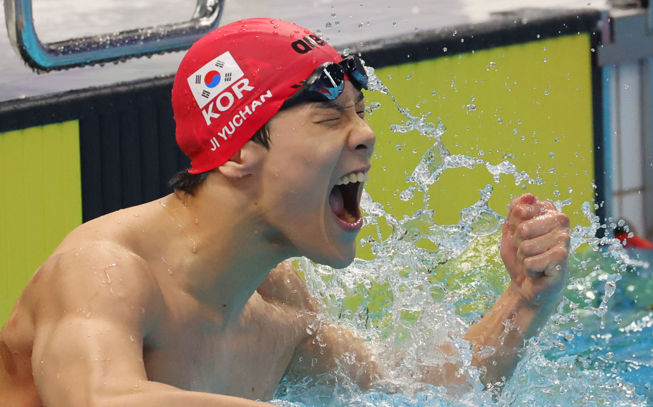 Ji Yu-chan of South Korea celebrates after winning the gold medal in the men's 50-meter freestyle swimming at the Asian Games at Hangzhou Olympic Sports Centre Aquatic Sports Arena in Hangzhou, China, on Monday. (Yonhap)