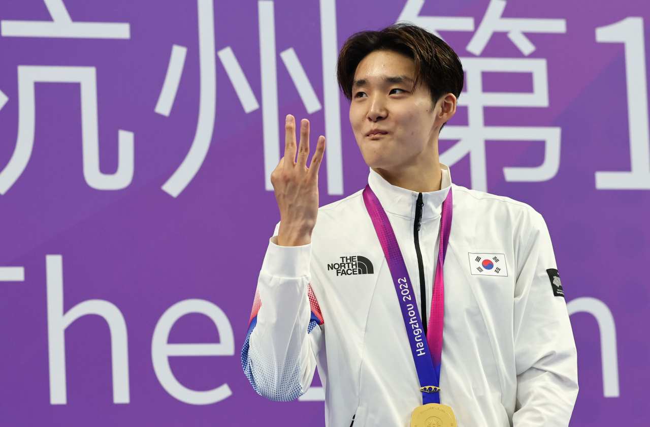 South Korean swimmer Kim Woo-min celebrates during the victory ceremony after winning gold in the men's 400-meter freestyle at the Asian Games at Hangzhou Olympic Sports Centre Aquatic Sports Arena in Hangzhou, China, on Friday. (Yonhap)