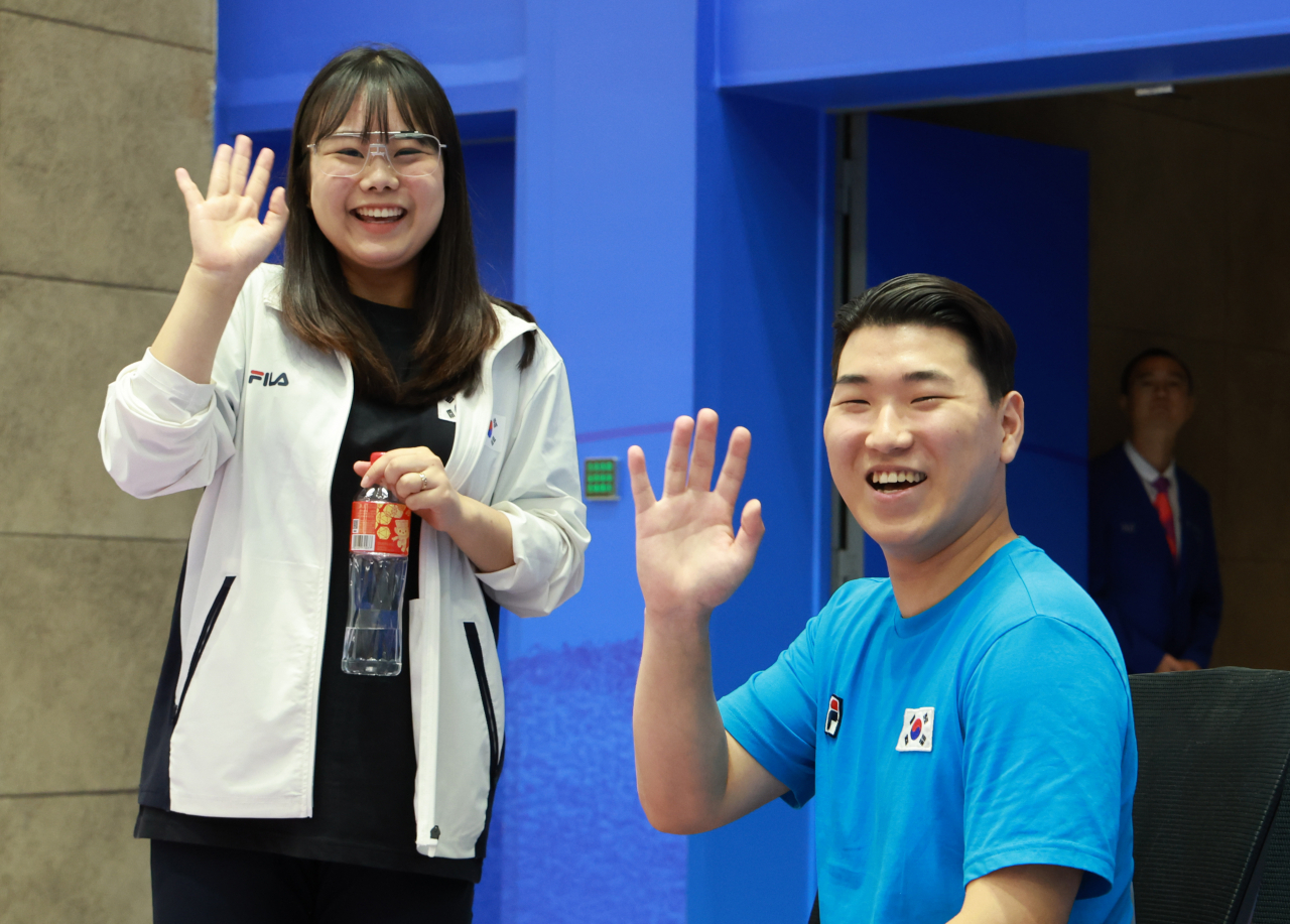 South Korean shooters Kim Bo-mi (left) and Lee Won-ho celebrate after winning bronze in the 10-meter air pistol mixed team event at the Asian Games Fuyang Yinhu Sports Centre in Hangzhou, China, on Sat. (Yonhap)