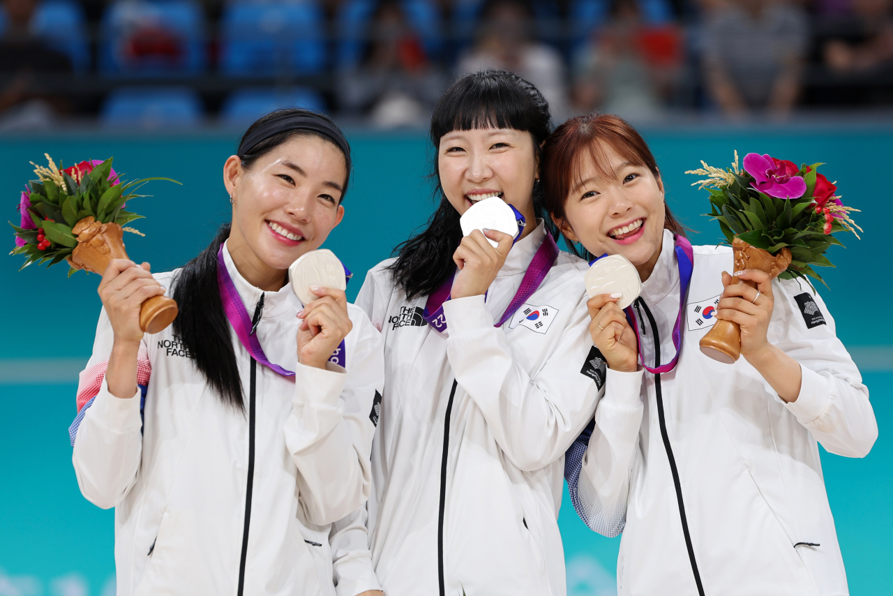 South Korean roller skaters Lee Seul, Park Min-jeong and Lee Ye-rim (L to R) celebrate on the podium during the victory ceremony after winning silver in the women's speed skating 3,000-meter relay at the Asian Games at Qintang Roller Sports Centre in Hangzhou, China, on Monday (Yonhap)