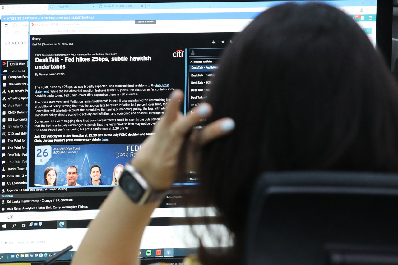 A Hana Bank dealer watches a news report on the US Fed’s rate hikes at a trading room in Seoul on Sept. 27. (Newsis)