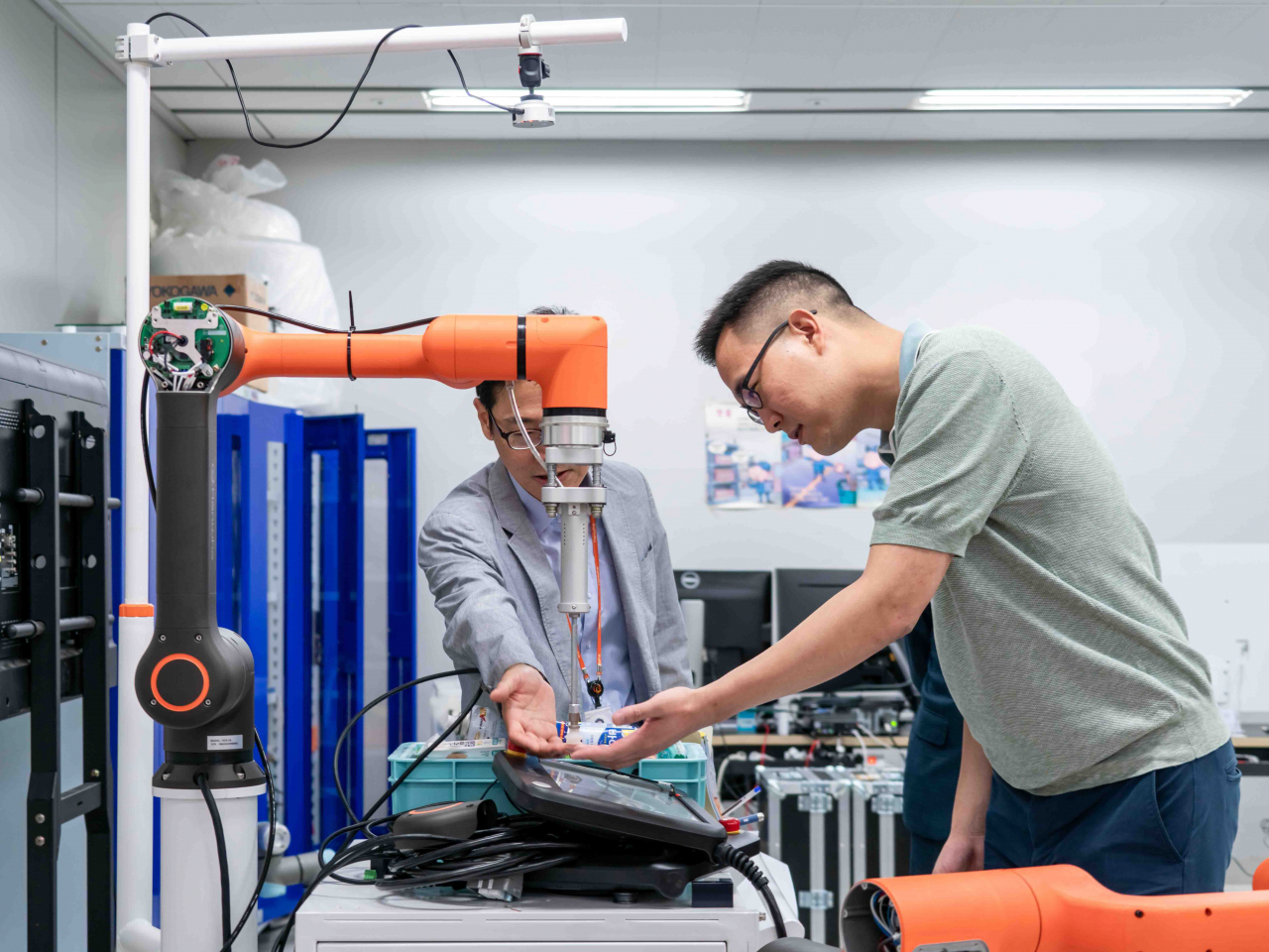 Kim Dong-sun (right), the youngest son of Hanwha Group Chairman Kim Seung-youn and executive director at Hanwha Hotels & Resorts, checks out Hanwha's collaborative robot at the company's future technology lab in Gyeonggi Province in September. (Hanwha Robotics)