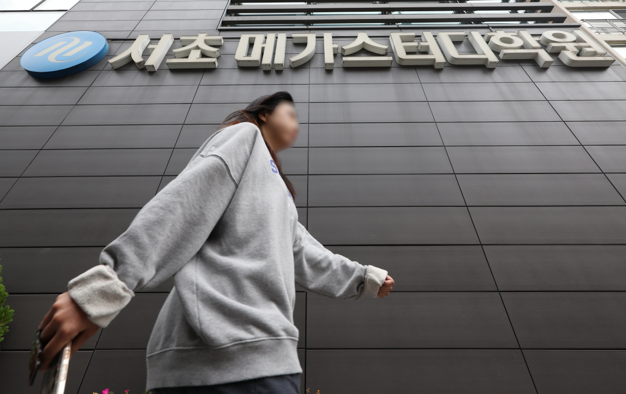 A student passes by Megastudy’s building, one of the country’s biggest private education academies, in Seoul’s Seocho-gu, on Wednesday. (Yonhap)