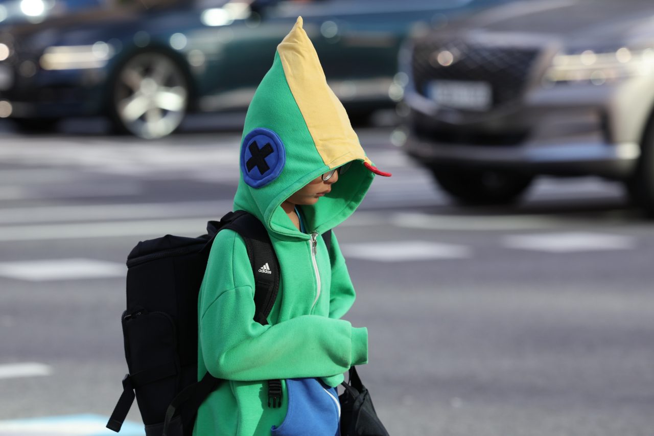 A child wearing a green hoodie walks near Gwanghwamun, central Seoul, on Thursday morning. (Yonhap)