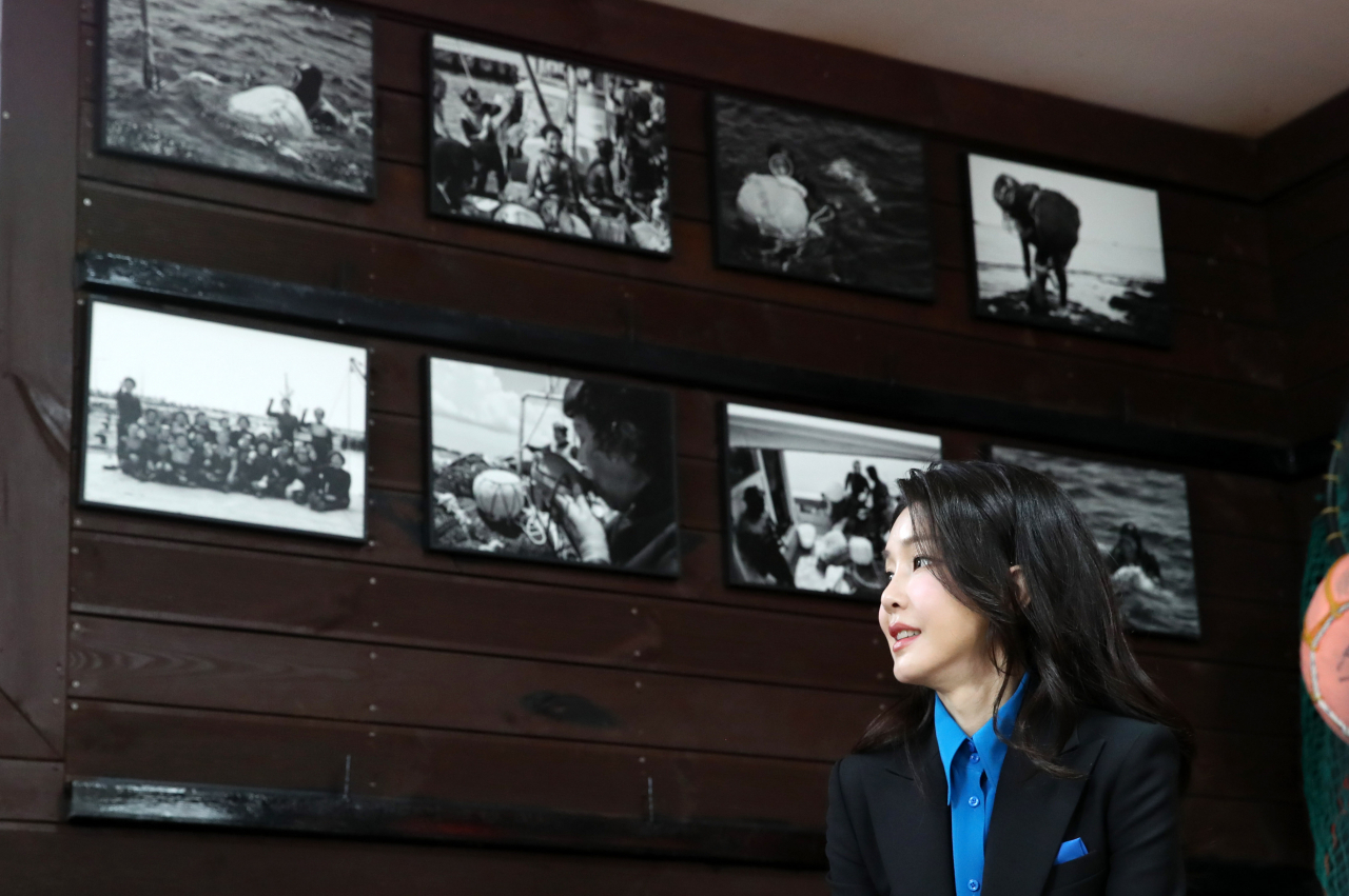 First lady Kim Keon Hee looks towards photos of haenyeo during a meeting with them on Jeju Island. (Yonhap)