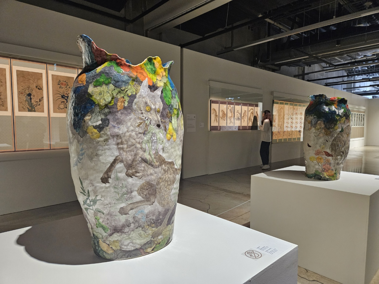 An installation view of Japanese artist Muta Yoka's pottery works (front) and embroidery folding screens collected by Chang Young-ran. (Park Yuna/The Korea Herald)