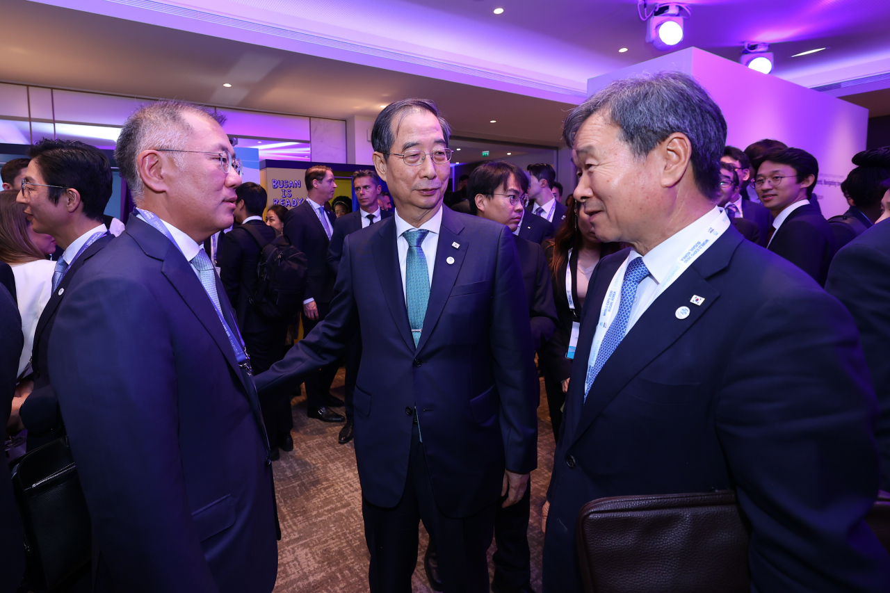 Prime Minister Han Duck-soo (second to right), who is on a tour of four European countries, talks with Hyundai Motor Group Chairman Chung Eui-sun (left) and Choi Jae-chul, the South Korean ambassador to France, at a 2030 Busan World Expo Symposium held in Paris on Monday afternoon, local time. (Yonhap)