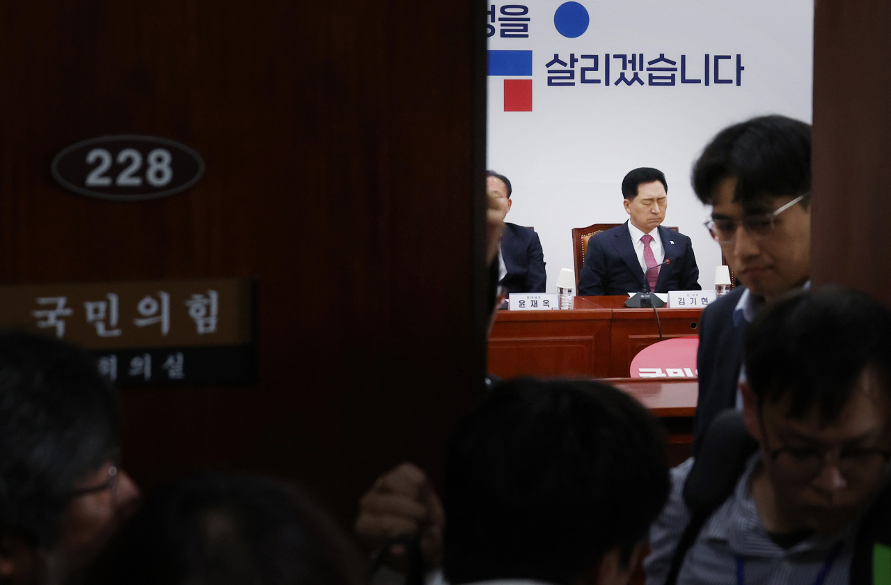 Ruling People Power Party leader Kim Gi-hyeon is seen attending a party leadership meeting as the venue's door is being closed at the National Assembly in Seoul, on Thursday. (Yonhap)