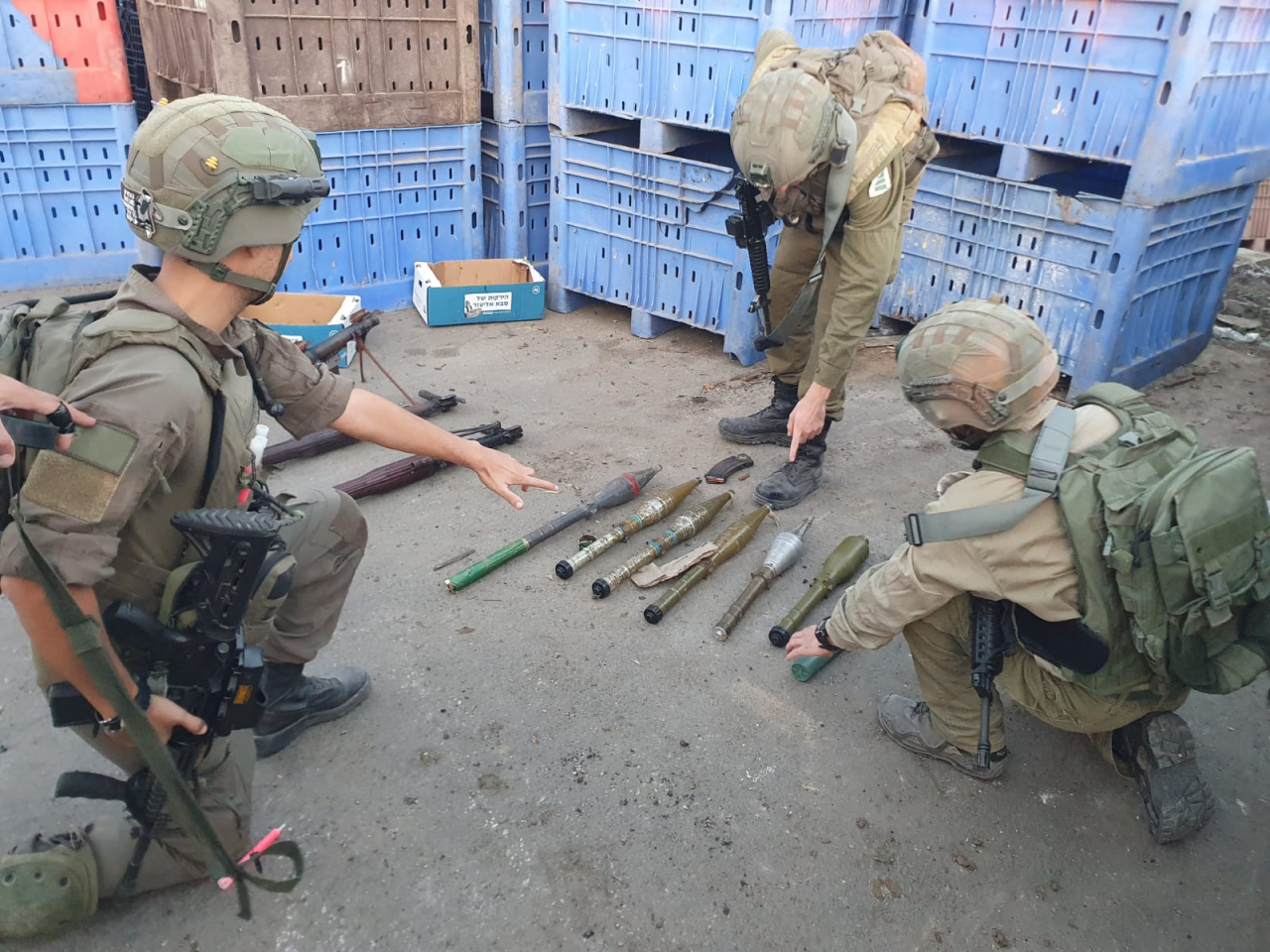 Israeli soldiers point to the weapons seized from Hamas. The item on the far left with red trimming is believed to be a North Korean-made F-7 rocket in the photo released by the Israel Defense Forces on Wednesday. (IDF)