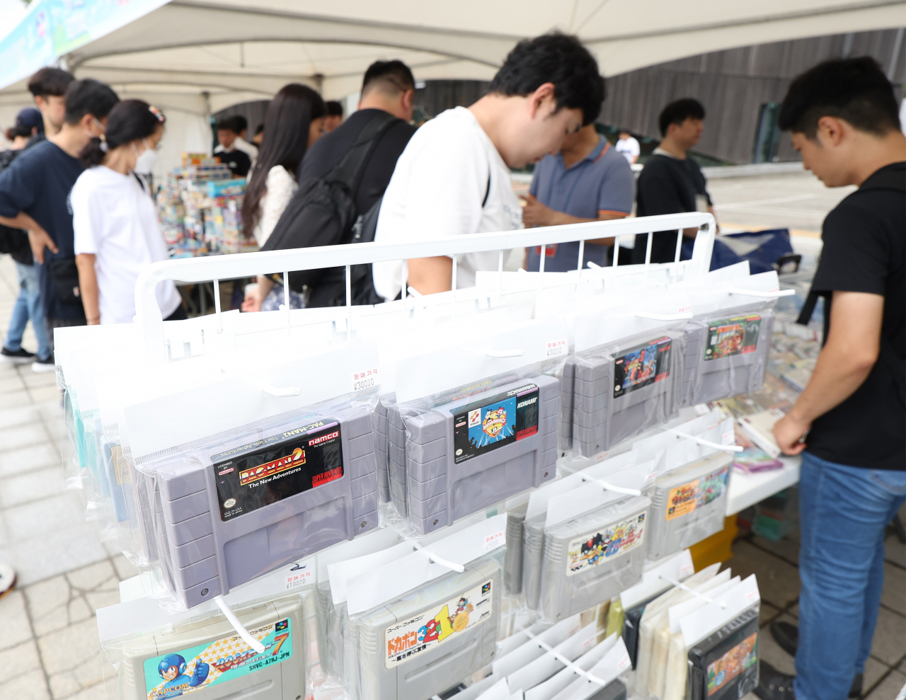 Participants of the 88 Green Festival, held in commemoration of the 1988 Summer Olympics in Seoul, look at retro video game cartridges at Olympic Park in Songpa-gu, southern Seoul, Sept. 17. (Yonhap)