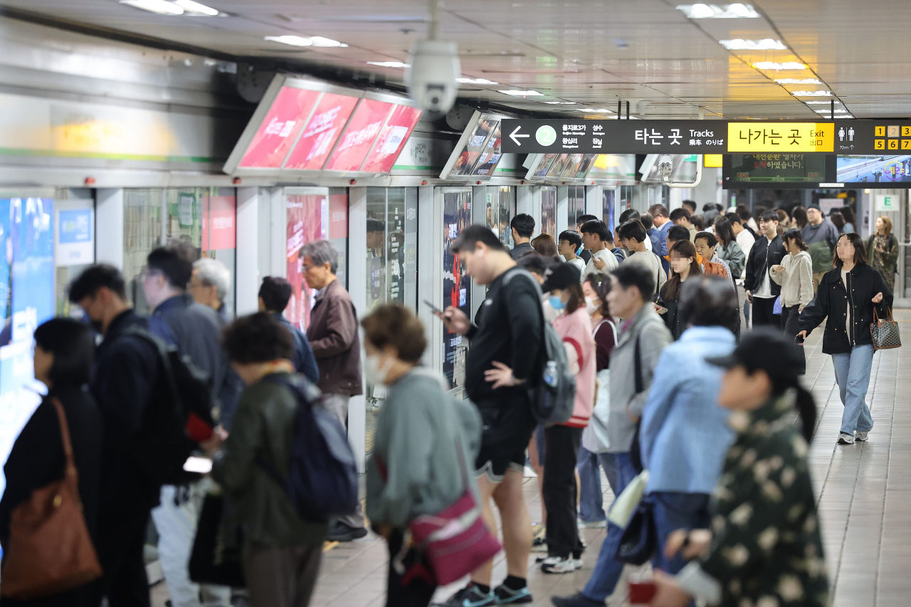 People are seen waiting in line for a subway train in Seoul (Yonhap)
