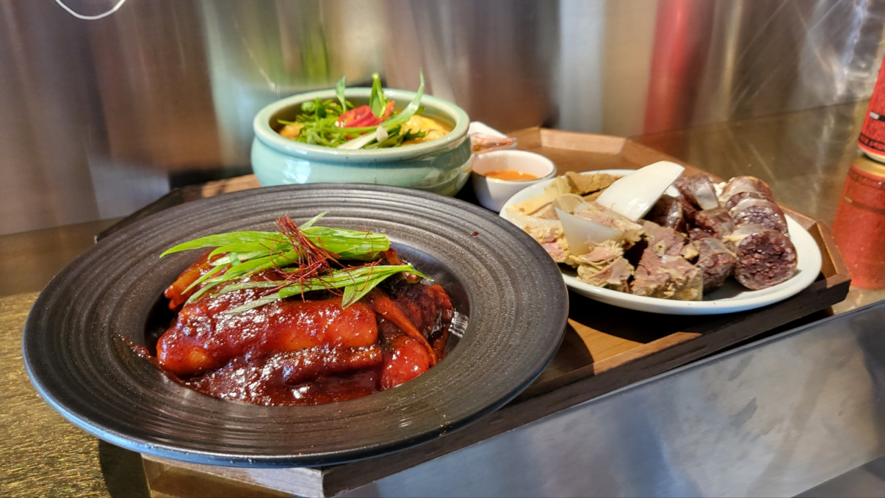 A plate of tteokbokki (spicy rice cakes), accompanied by a side of eomuktang (fishcake soup) and sundae (blood sausage), served at Tteoksan (Kim Hae-yeon/ The Korea Herald)