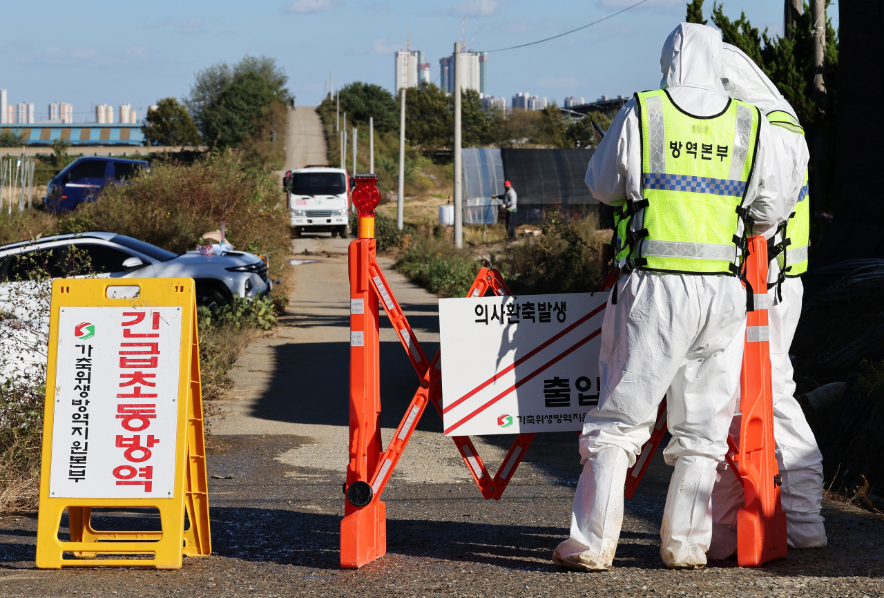 A quarantine official blocks a road leading to a pig farm in Hwacheon, Gangwon Province, northeastern South Korea, on Sept. 26, after another case of African swine fever was confirmed there. (Yonhap)