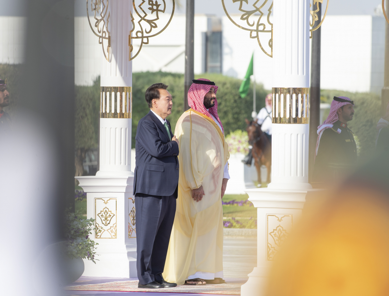 President Yoon Suk Yeol, who is on a state visit to Saudi Arabia, salutes the South Korean national flag with Crown Prince Mohammed bin Salman at the official welcoming ceremony held at Al Yamamah Palace in Riyadh on Sunday. (Yonhap)